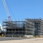 クレーンと足場が組まれた大型建築工事の現場全景