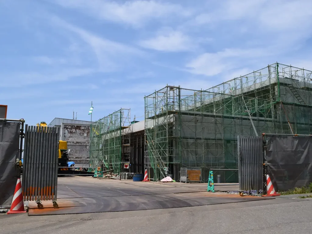 工事中の施設入口と、足場に囲まれた建物の外観
